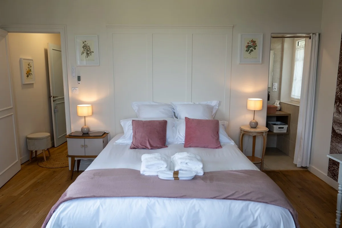 Chambre Mont Blanc — lit habillé de linge blanc et coussins roses